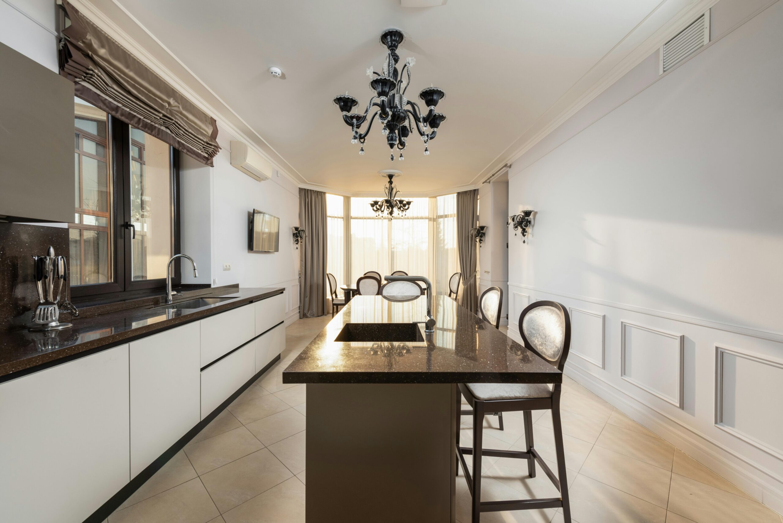 A beautiful kitchen area with sunlight streaming through elegant window treatments, creating a warm and inviting ambiance